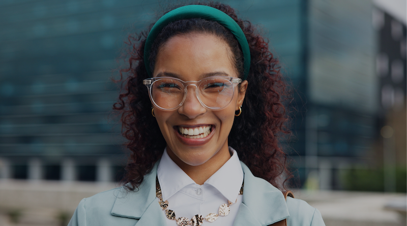 image of a person smiling outside of a building